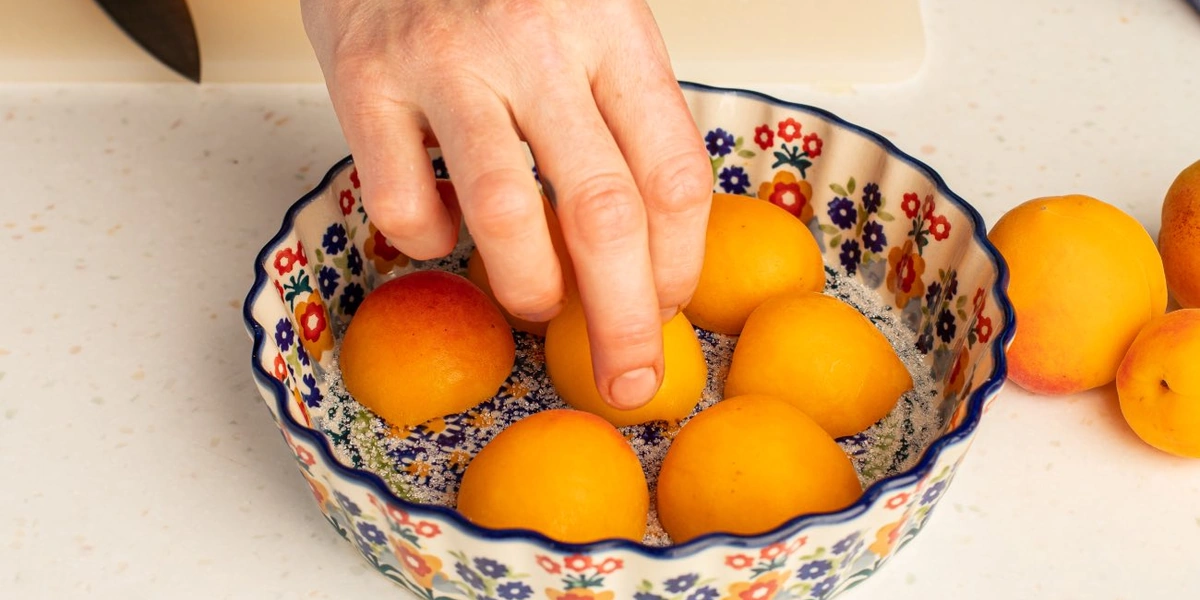 На дно формы для&nbsp;выпечки насыпьте сахар, положите абрикосы