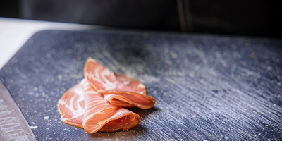 Выдержанную сыровяленую шейку можно оригинально подать, сложив волнами