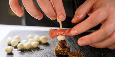 Сверните ломтики колбасы, хлеб нарежьте одинаковыми кусочками. Последовательно наколите на&nbsp;шпажку колбасу, сыр, оливку и&nbsp;хлеб