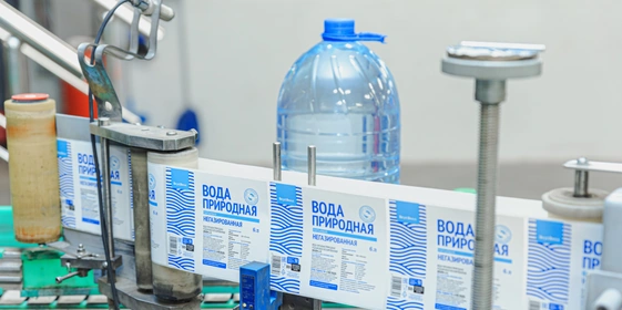 Наполненная водой бутылка поступает по&nbsp;транспортёру на&nbsp;этикетировку